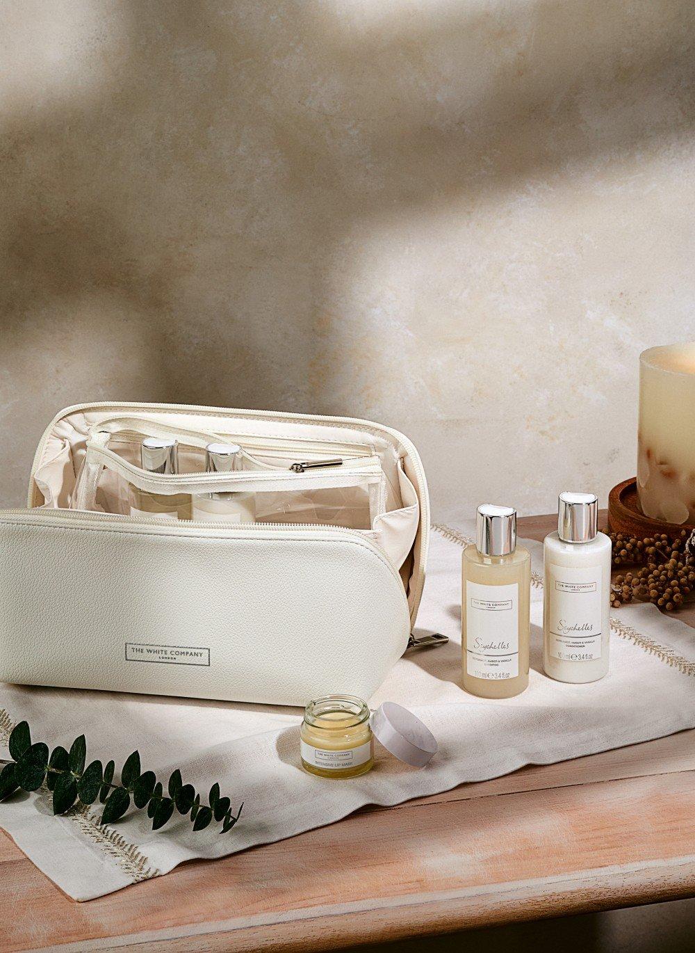 a white bag with various items on a table next to a candle