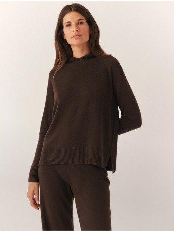 a woman posing in a brown jumper