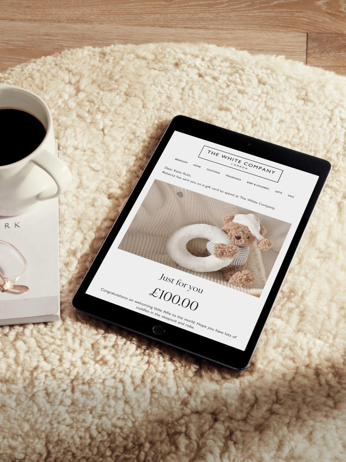 a tablet computer sitting on a rug next to a cup of coffee
