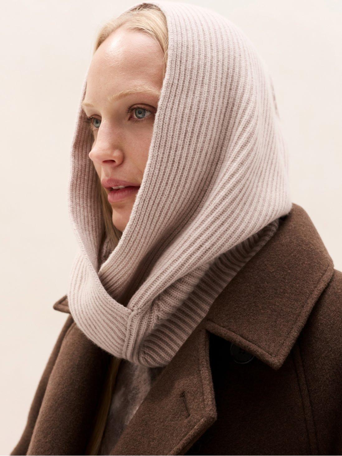 a woman wearing a scarf and a coat with a hood