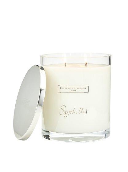 a white candle with a lid that says seychelles