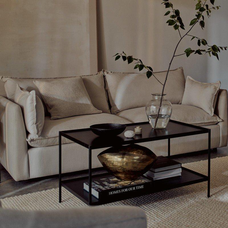 a living room with a couch, coffee table, and vase