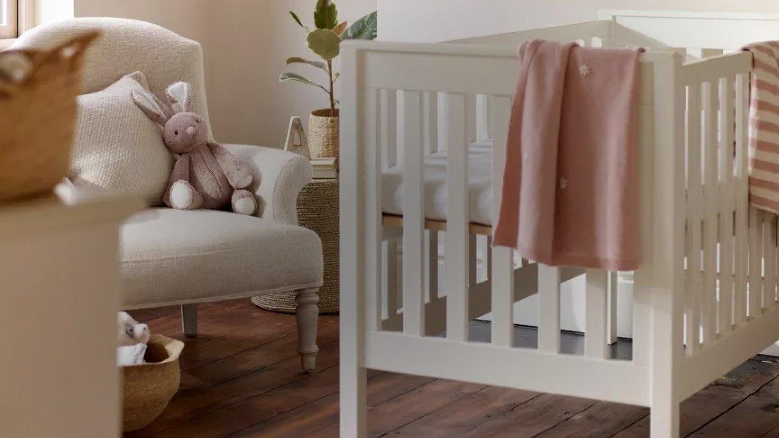 a baby crib in a room with a chair and a chair