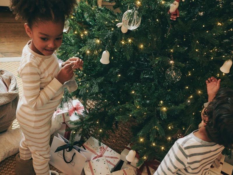a group of children in pajamas around a christmas tree