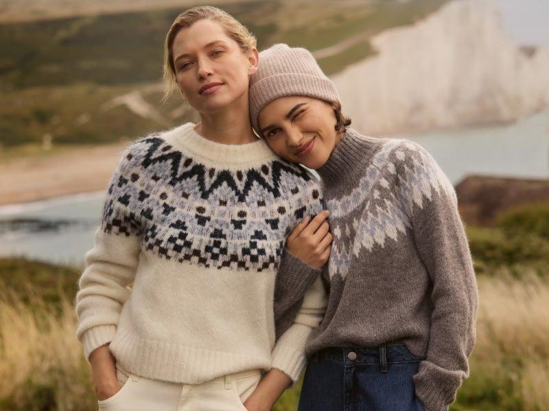 two women are standing next to each other in a field