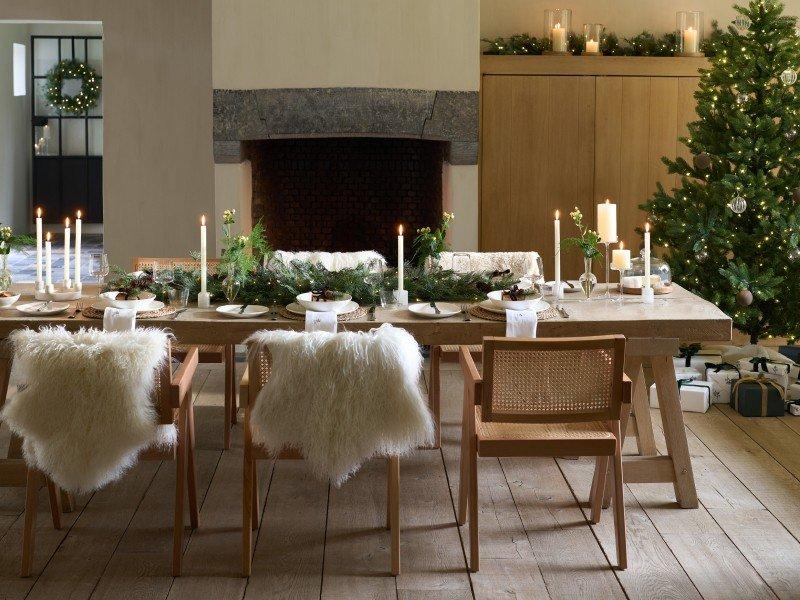 a dining room with a table and chairs and a christmas tree