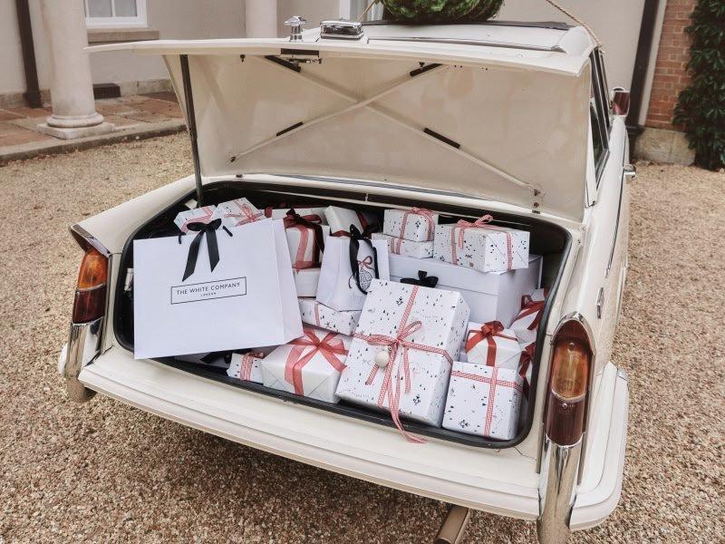 a trunk full of wrapped presents in the back of a car