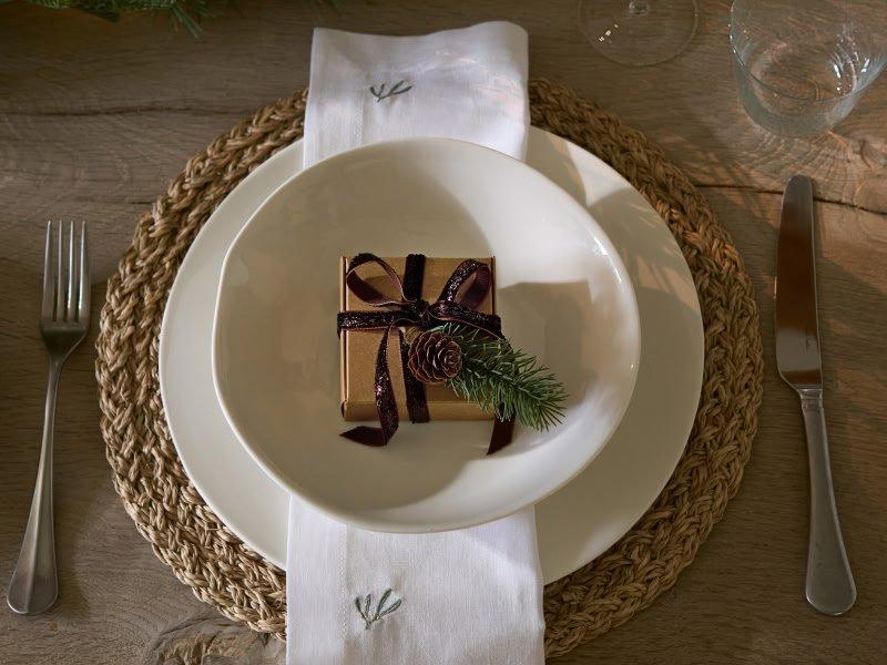 a plate with a gift wrapped in a napkin on a table