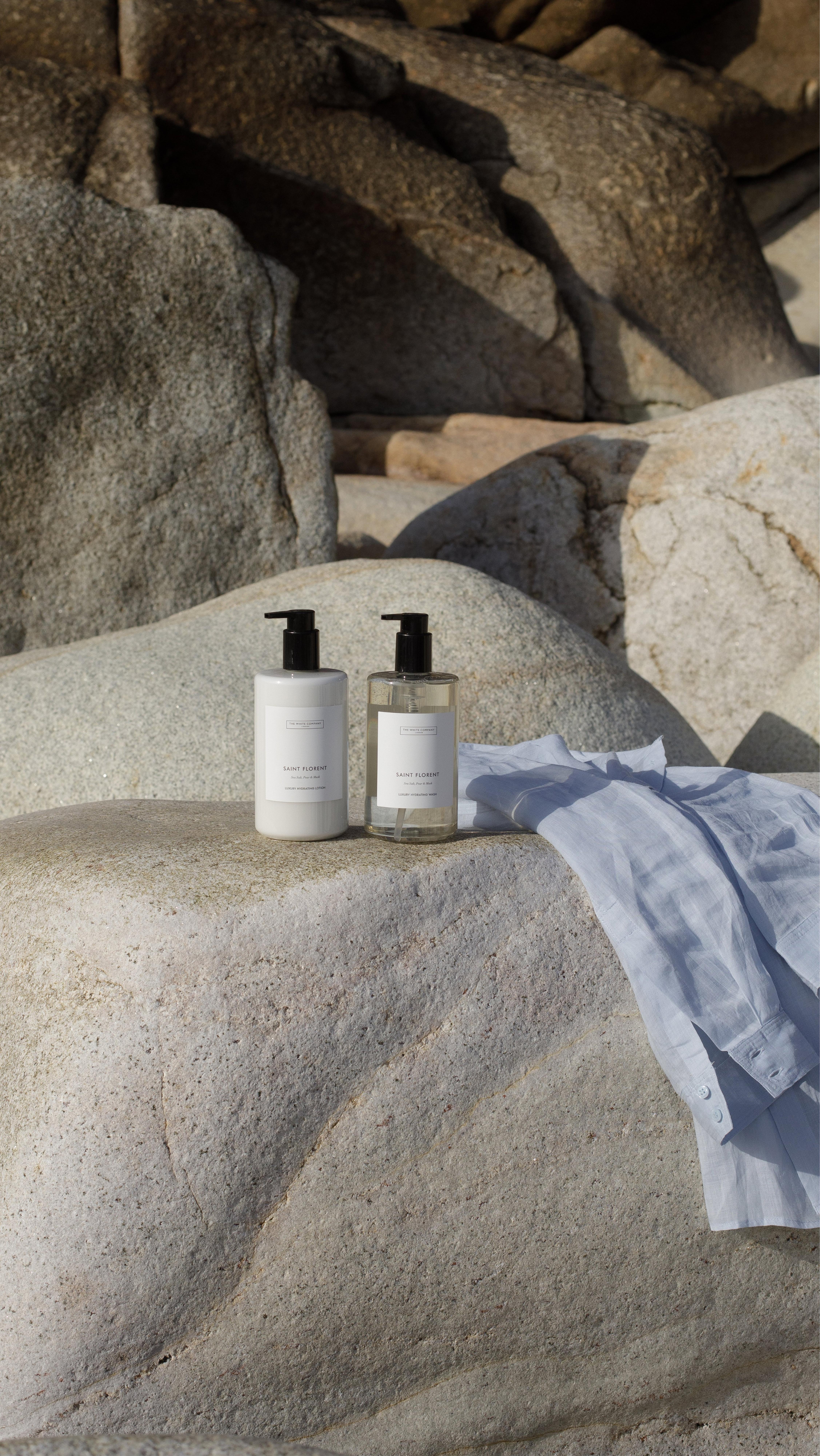 a bottle of lotion and a towel sitting on a rock