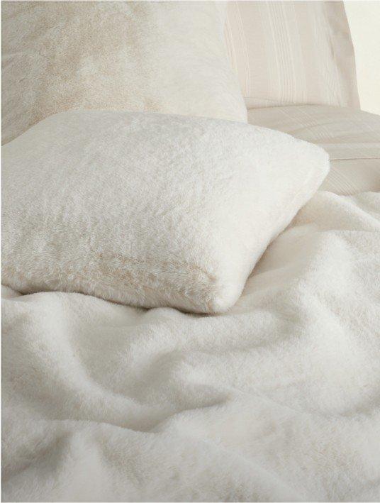 a white pillows on a bed with a white comforter