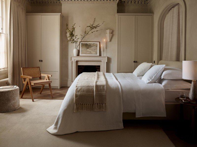 a bedroom with a fireplace and a bed with a white blanket