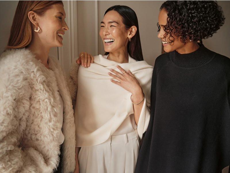 a woman in a black striped jumper holding a purse