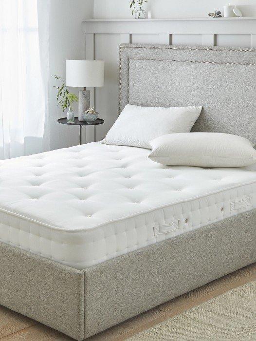 a bed with a mattress and pillows in a room