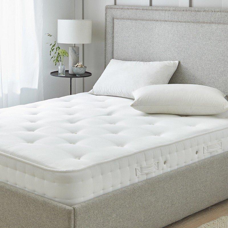 a bed with a mattress and pillows in a room