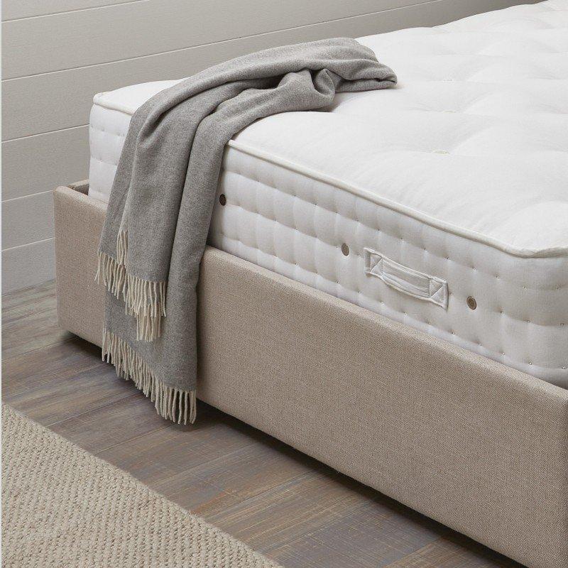 a mattress with a blanket draped over it on a bed