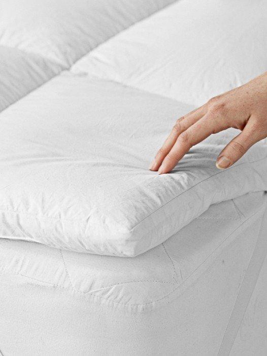 a close up of a pillow on a bed with a white cover