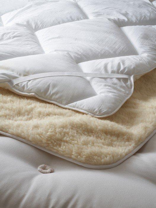 a close up of a pillow on a bed with a white cover