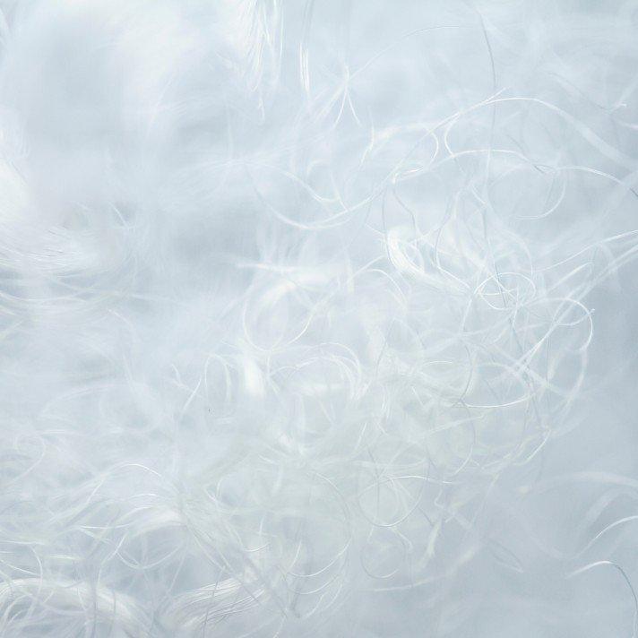 a pile of pillows on a bed with a white sheet