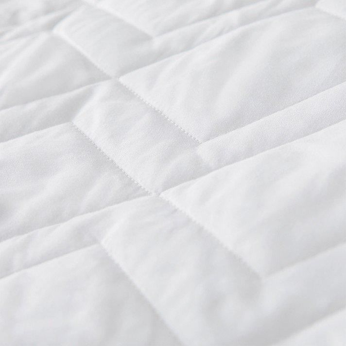 a close up of a white fluffy bedspread and a white fluffy pillow