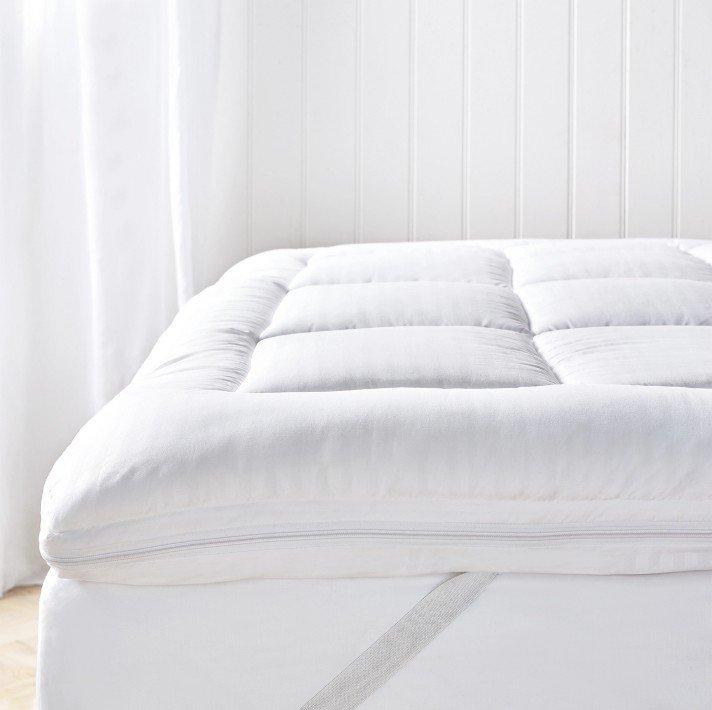 a pile of pillows on a bed with a white sheet