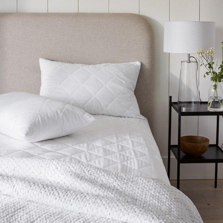 a close up of a white fluffy bedspread and a white fluffy pillow