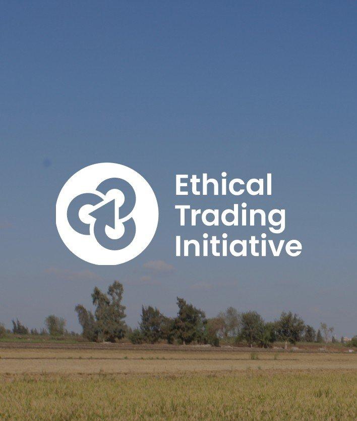 a white and blue logo of ethical trading initiative in a field