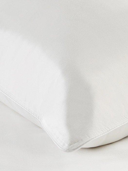 a close up of a white pillow on a bed