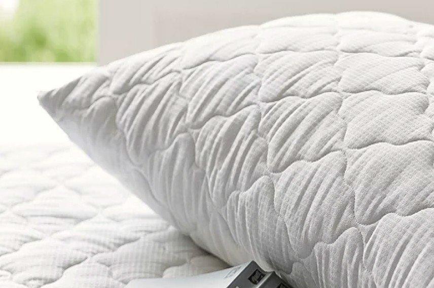 a pillow with a remote control sitting on top of it