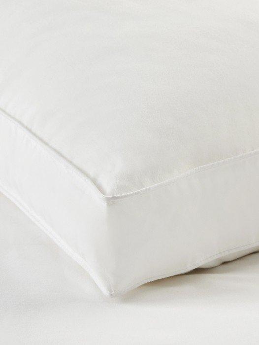 a close up of a white pillow on a bed