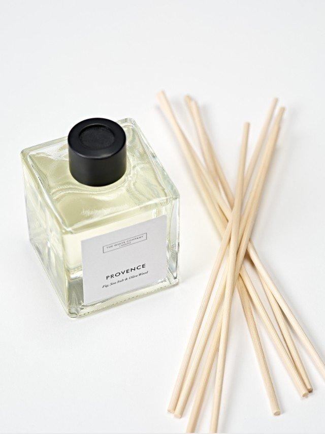 a bottle of perfume and some sticks of incense