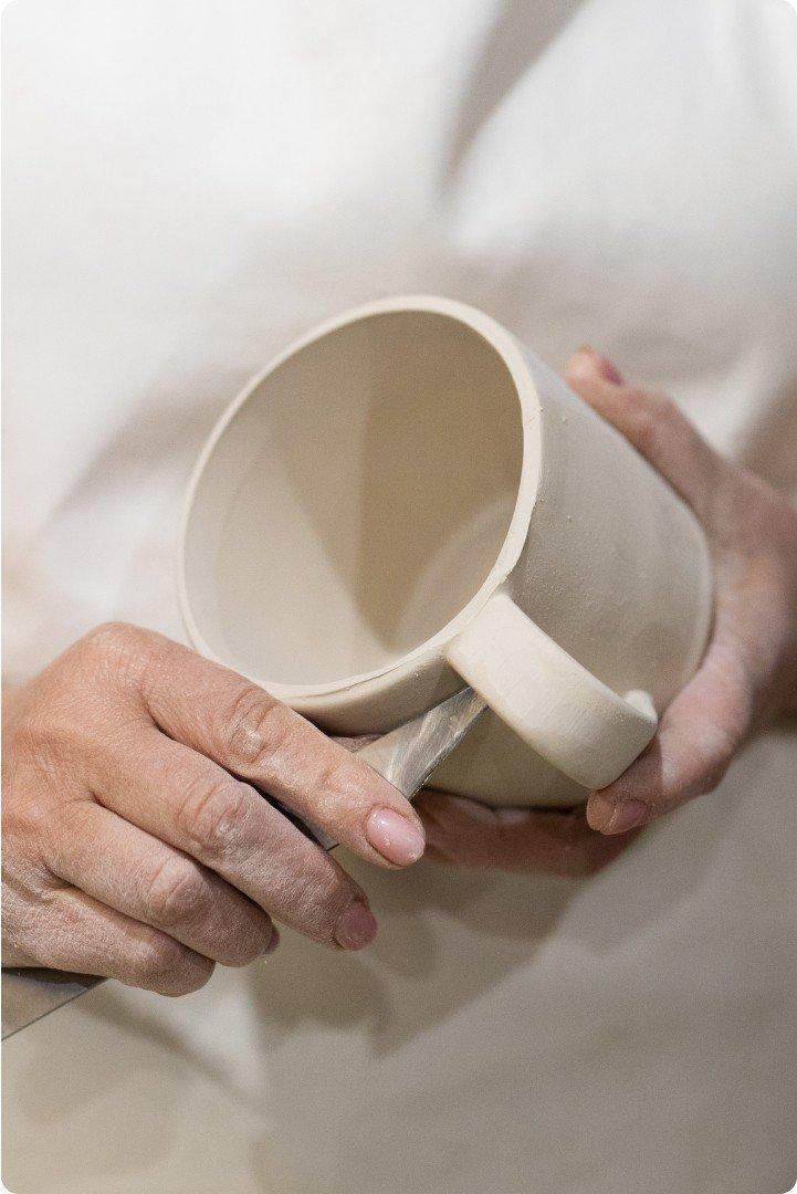 a person holding a cup with a handle and a handle