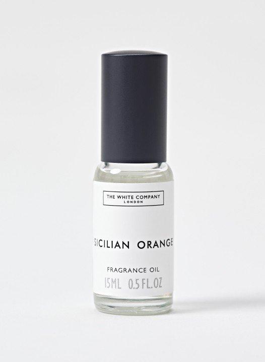 a bottle of orange oil on a white surface