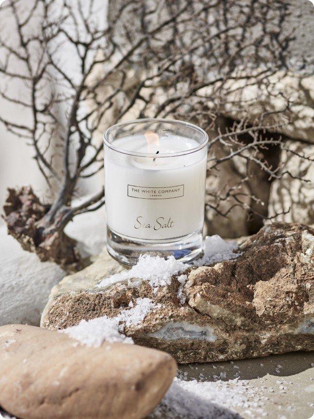 a candle sitting on a rock next to some snow