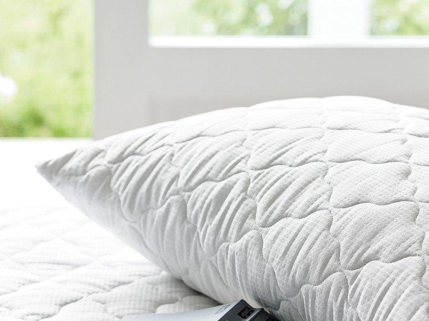 a pillow with a remote control sitting on top of it