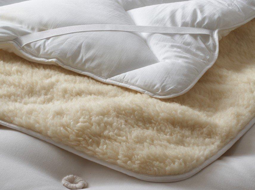 a bedroom with a bed, chair, and ottoman in it