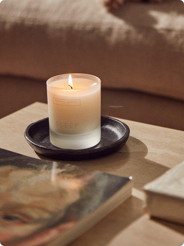 a candle sitting on a table next to a book