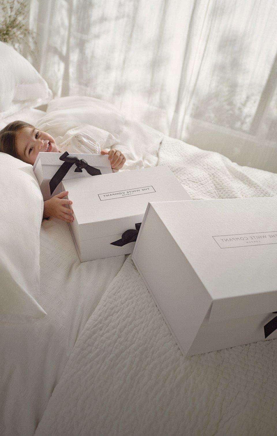 a couple of white boxes with black bows sitting on a table
