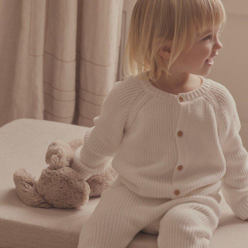 two pictures of a baby and a toddler laying on a bed