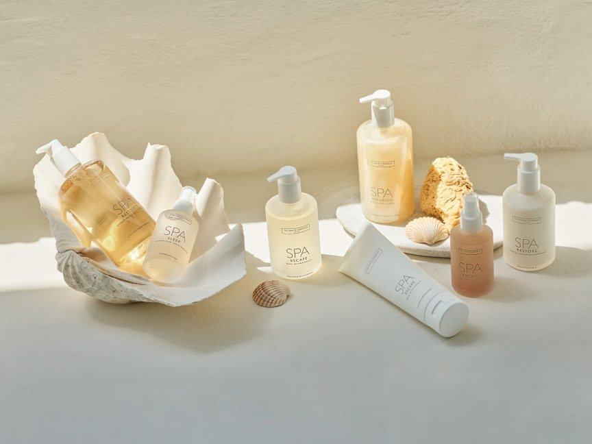 a white table with a shell and a bottle of lotion