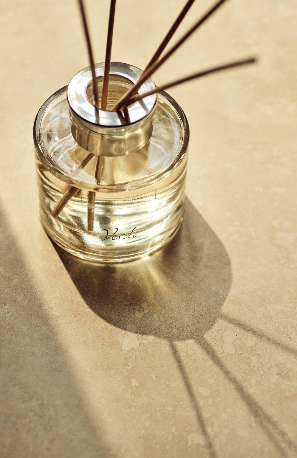 a glass jar with sticks of incense in it on a table