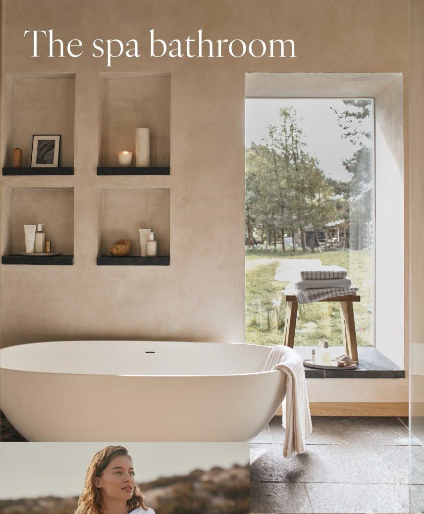 a bathtub in a bathroom with a window and shelves