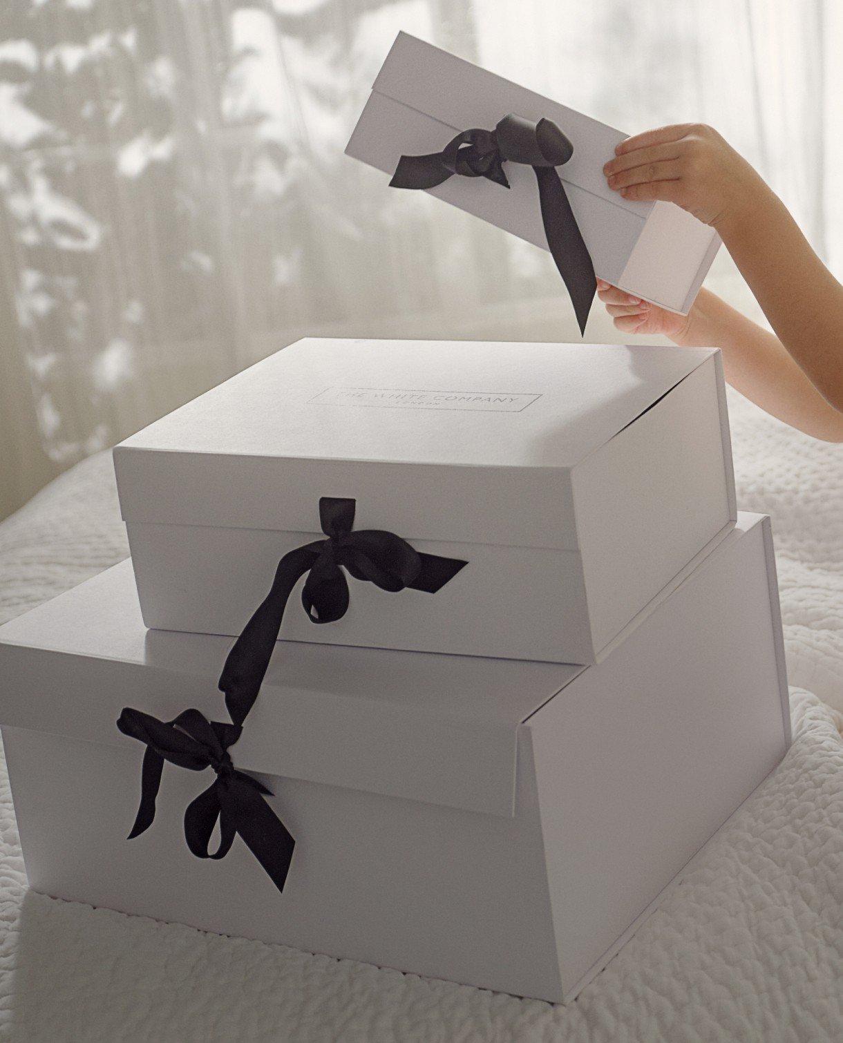 a person is opening a box with a bow on it