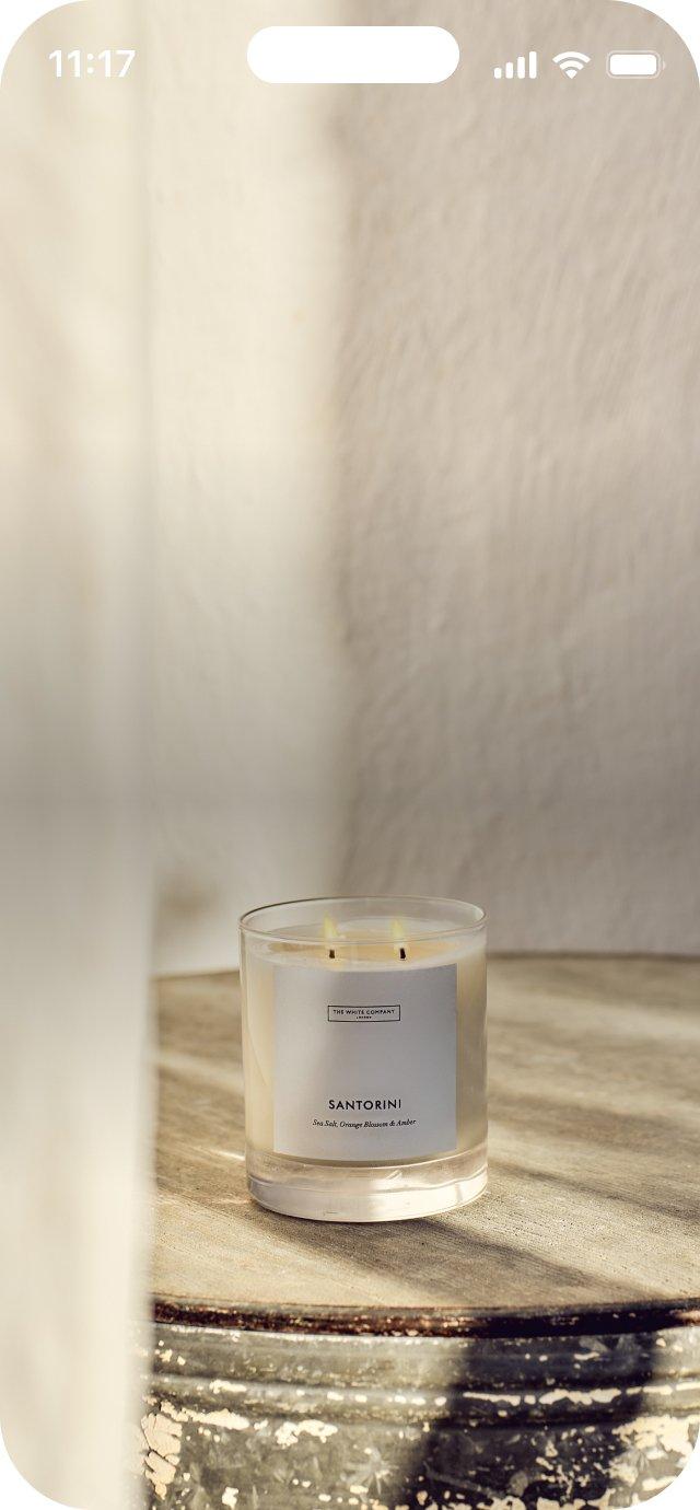 a candle sitting on a table in a room with a window