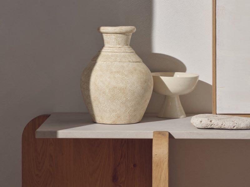 two vases sitting on a white counter top next to each other