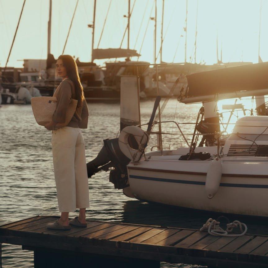 a woman standing on a dock next to a boat