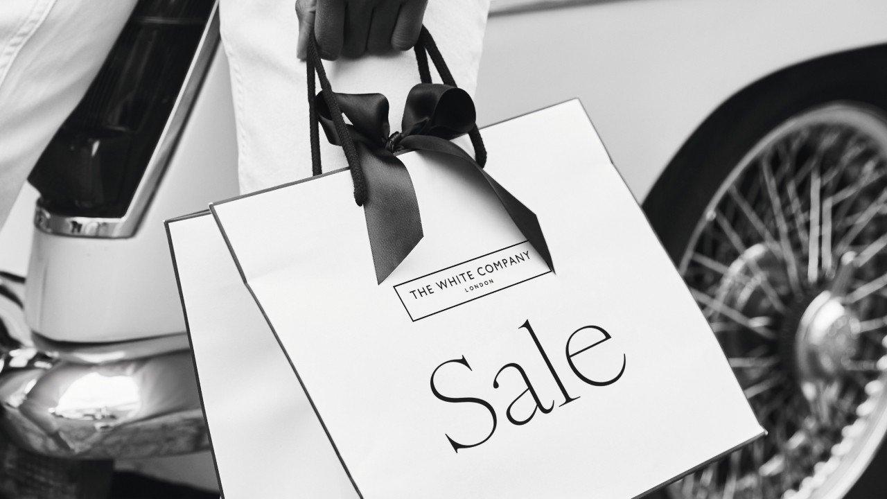 a black and white photo of a white bag with a sale sign