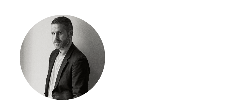 a man in a suit and tie standing in front of a round circle