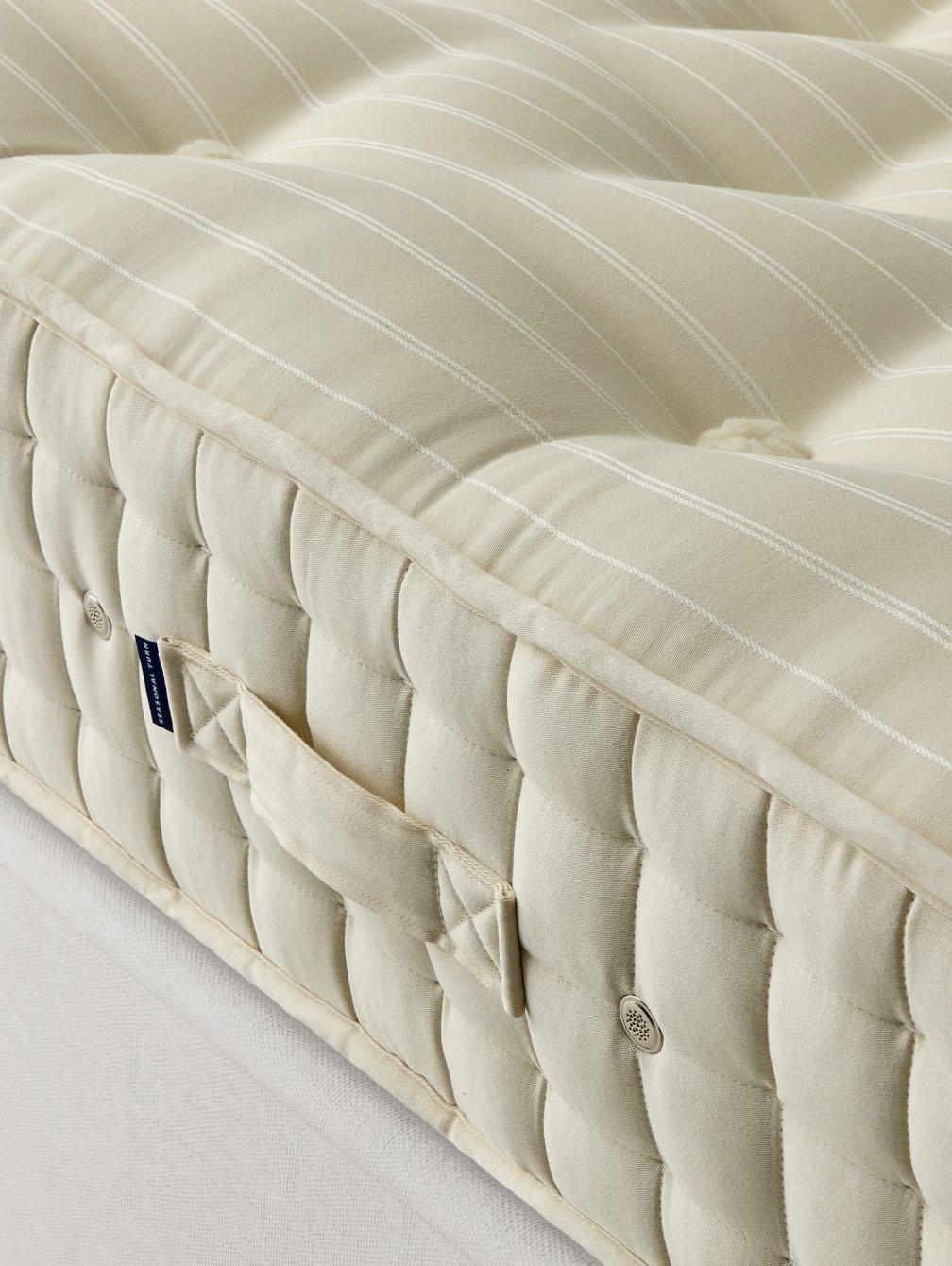 a close up of a mattress with a white cover