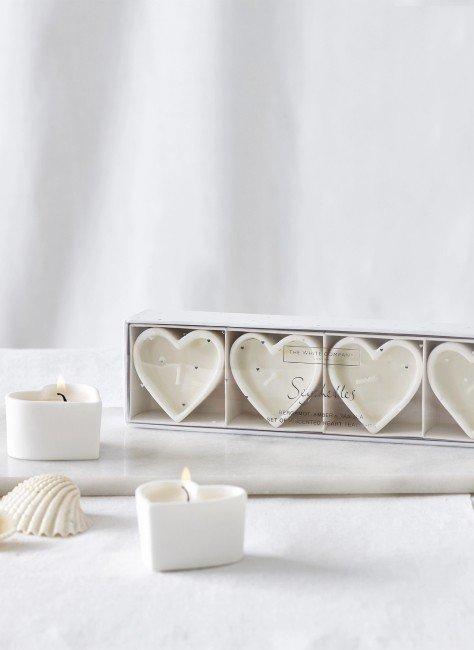 a white box with three heart shaped tea lights in it