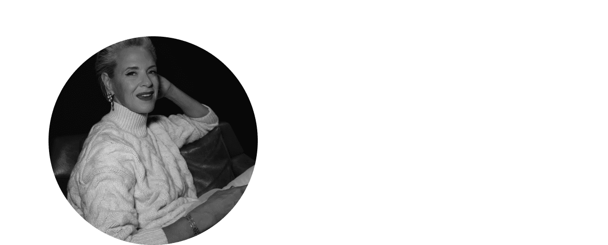 a woman in a sweater sitting on a couch with a book